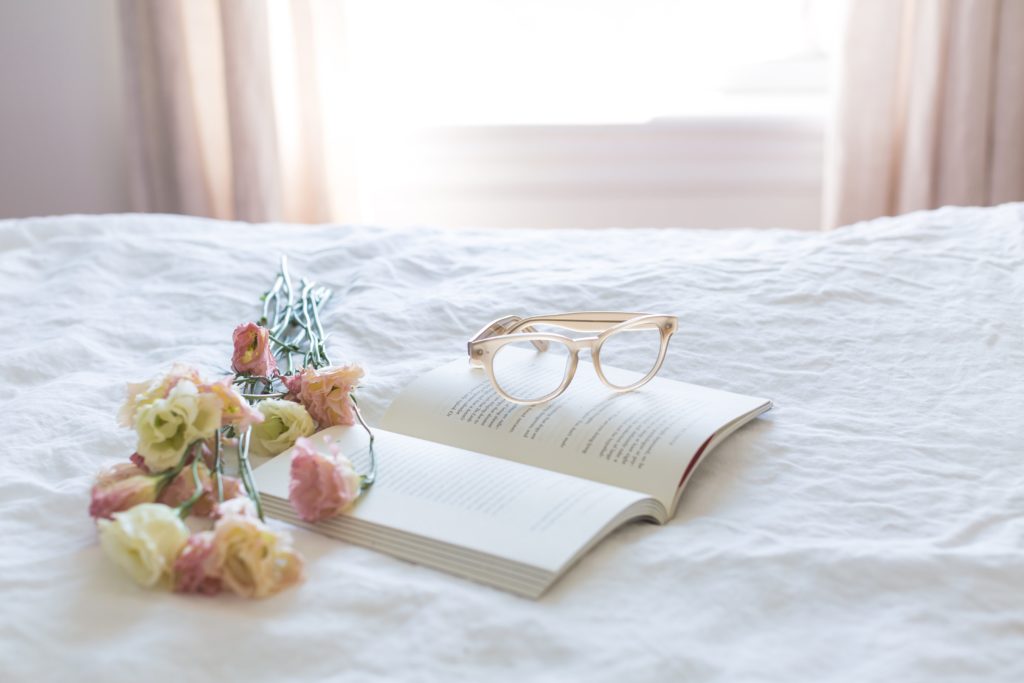 an open book with glasses on top and flowers next to it
tips for an easier week